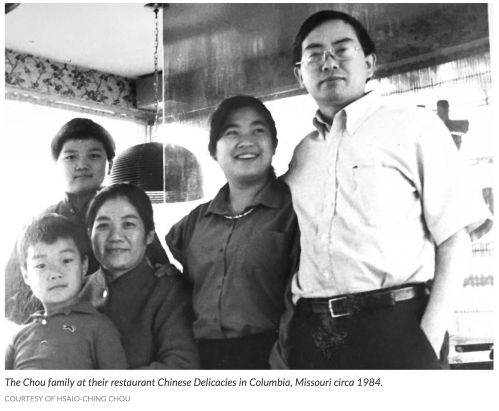 A black and white photo of Hsiao-Ching's family from around 1984. Hsiao-Ching is standing next to her father on her left. On her right is her mother, seated, with Hsiao-Ching's youngest brother on her lap. HC's brother Sam is standing behind mom.